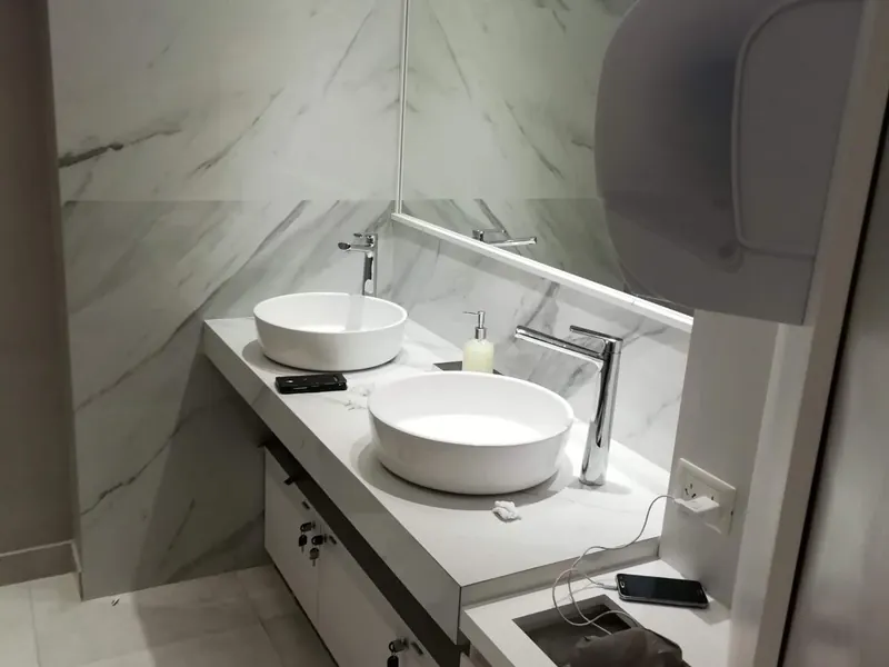 Baño reformado con doble lavabo sobre encimera y espejo
