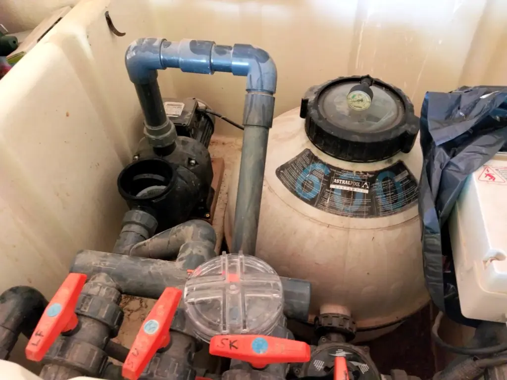 Sand filter and valves in the plant room of a private pool