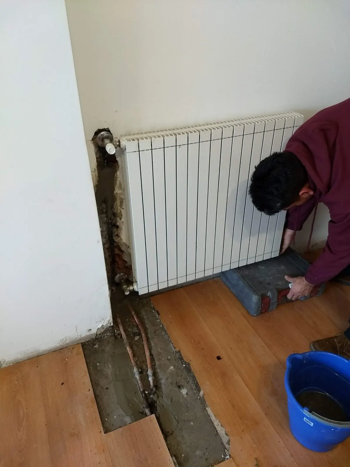 Técnico instalando un radiador de calefacción en una vivienda