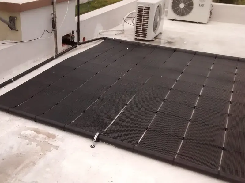 Campo de captadores solares para calentar el agua de una piscina, instalado en cubierta