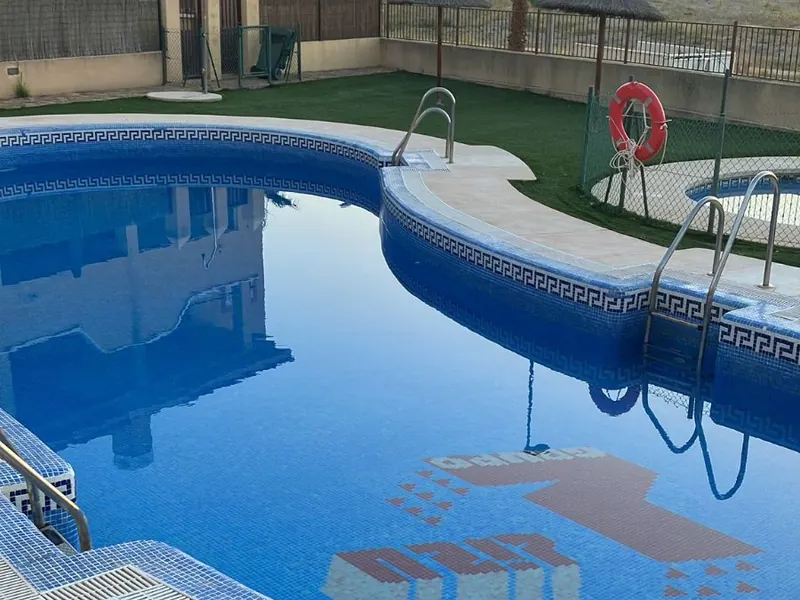 Piscina con el agua limpia después del mantenimiento, con su borde y escalera