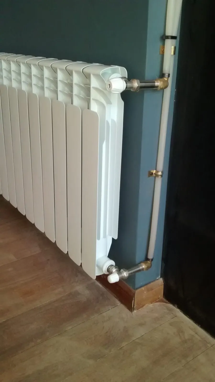Radiador de aluminio con las tomas de ida y retorno de la calefacción a la vista