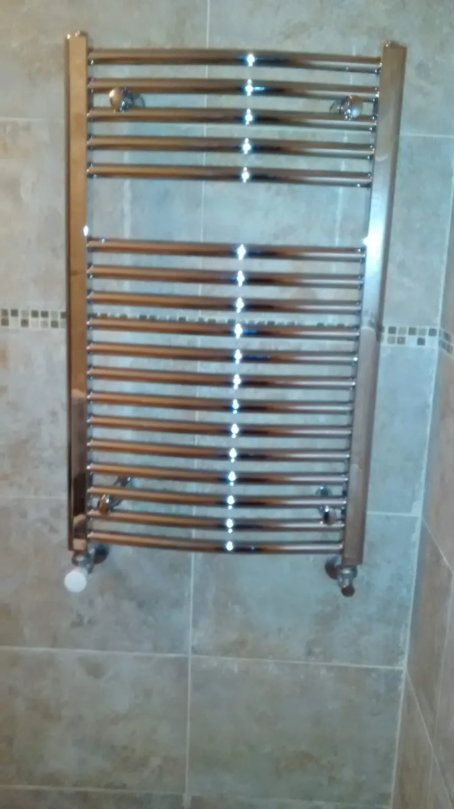 Radiador toallero instalado en un cuarto de baño