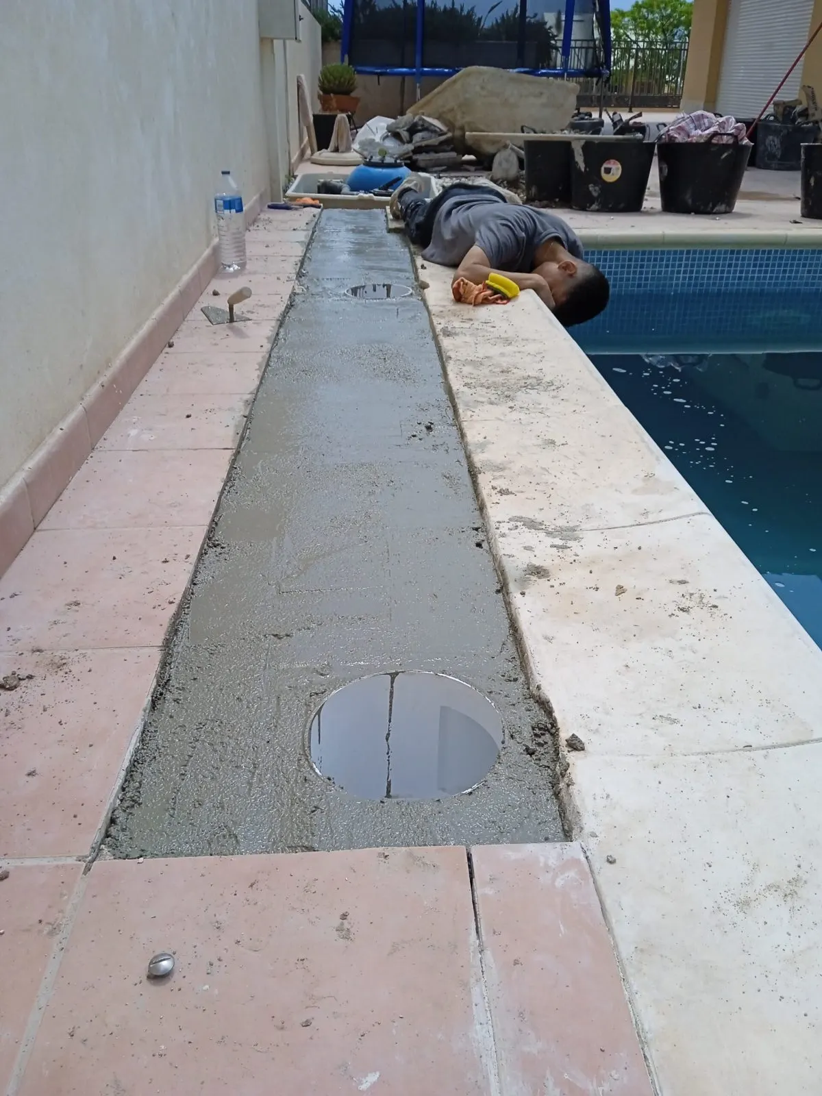 Trench opened along the edge of a pool to repair a leak in the pipework