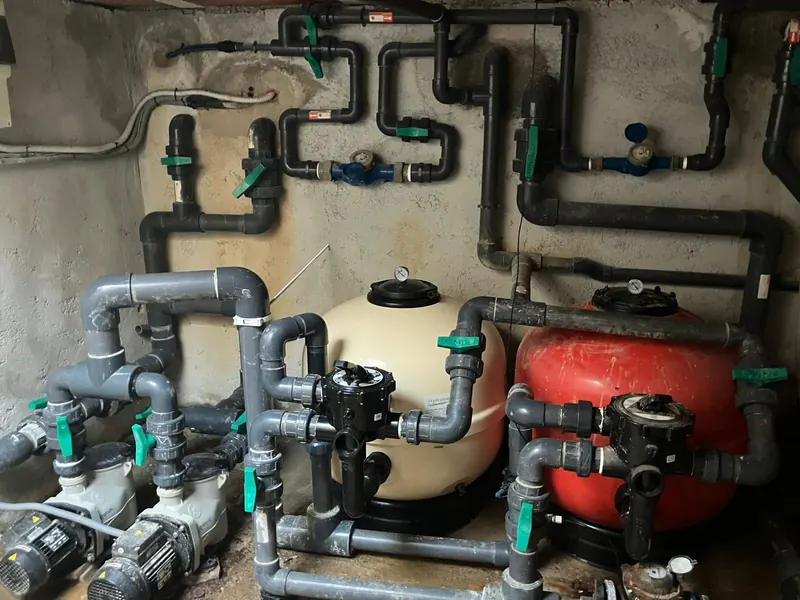 Sala de depuración de una piscina con el filtro, la bomba y la valvulería