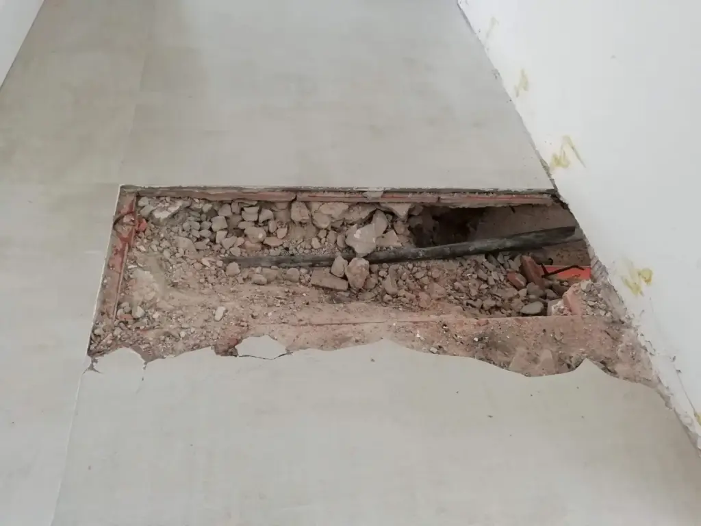 Suelo levantado en el punto exacto para reparar una fuga de agua localizada