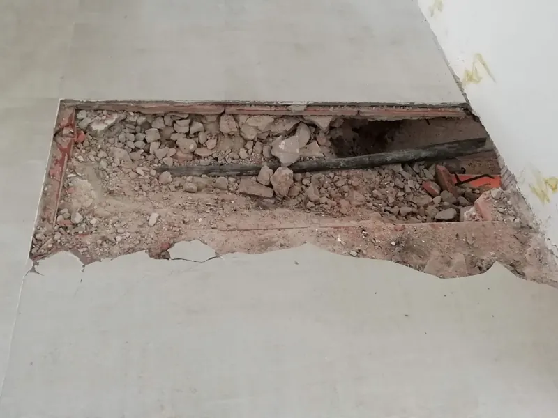 Suelo levantado en el punto exacto para reparar una fuga de agua localizada