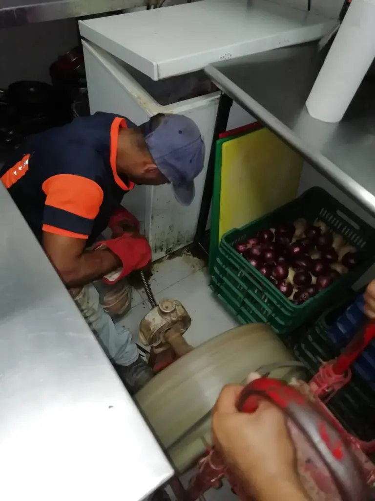 Técnico reparando una instalación de agua en un comercio
