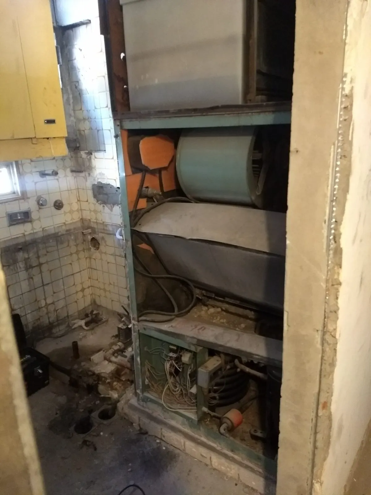 Termo eléctrico antiguo en el hueco de una cocina antes de su sustitución