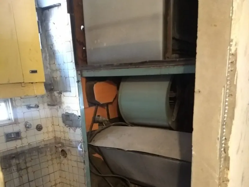 Termo eléctrico antiguo en el hueco de una cocina antes de su sustitución