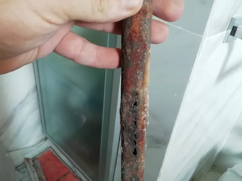 Tramo de tubería de cobre corroída retirado durante una reparación